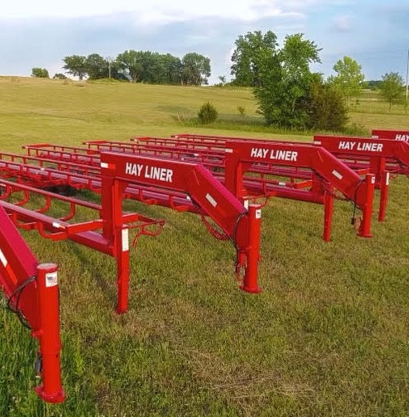 Stack of hay bales ready for transport with Brad's Welding Shop hay liner trailer